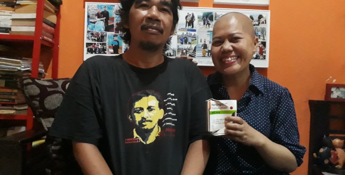 Juniarti (memegang kotak obat Trastuzumab atau Herceptin) dan  suaminya Edy Haryadi di rumah mereka, Duren Sawit, Jakarta Timur (law-justice.co/ Nikolaus Tolen)