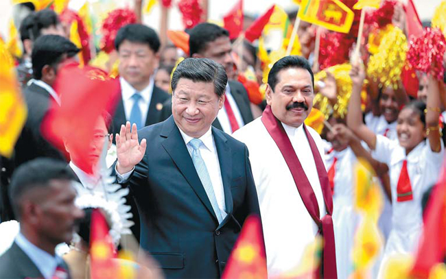 Presiden Xi Jinping melambaikan tangan ke pertemuan itu saat dia berjalan dengan Presiden Sri Lanka Mahinda Rajapaksa setelah tiba di bandara di Kolombo, Sri Lanka, pada hari Selasa. [Foto/Agencies]