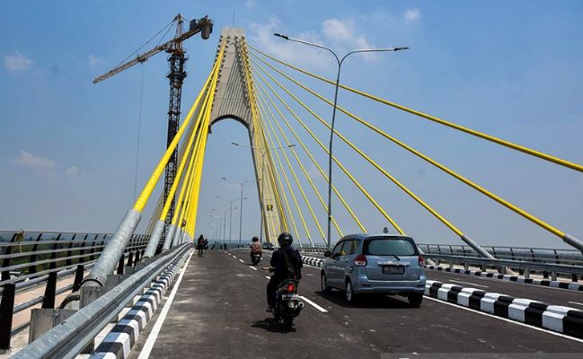 Warga menggunakan kendaraan bermotor melintasi Jembatan Siak IV yang sudah dibuka untuk umum di Kota Pekanbaru, Senin (18/3/2019). (Antaranews)