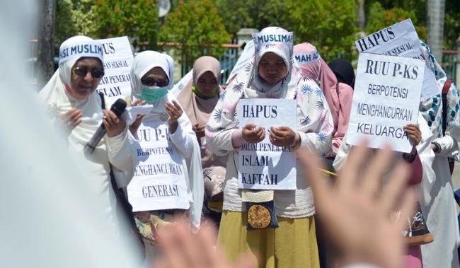 Pengunjuk rasa tergabung dalam Aliansi Muslimah Aceh mengusung poster dan spanduk pada aksi damai di DPR Aceh, Banda Aceh, Senin (8/4). Aliansi Muslimah Aceh mendesak DPR Aceh dan pemerintah menolak Rancangan Undang-Undang Penghapusan Kekerasan Seksual (RUU-PKS) karena berpotensi melemahkan ketahanan negara, dan mengabaikan peran agama dan adat istiadat serta berpotensi maraknya seks bebas, aborsi dan LGBT. Antara Foto