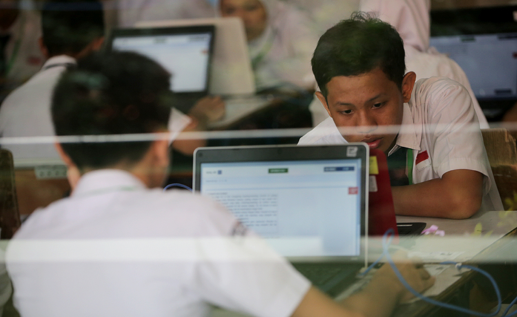 Siswa siswi SMP 1, Jalan Cikini, Jakarta serius mengerjakan soal ujian Nasional Berbasis Komputer. Robinsar Nainggolan