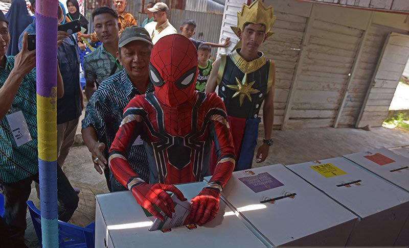 Pemilih menggunakan kostum Spiderman dan Gatotkaca menggunakan hak pilihnya di TPS 01 Kelurahan Pematang Kapau, Kota Pekanbaru, Riau, Rabu (17/4/2019). (Antara)
