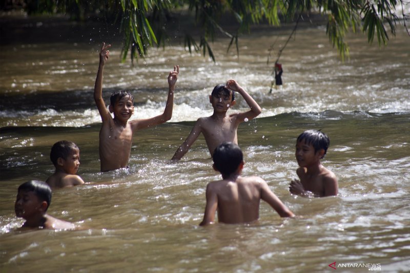 Ilustrasi - Sejumlah anak memanfaatkan hari libur dengan bermain di aliran Sungai Ciliwung, Depok, Jawa Barat, Jumat  (19/4/2019). 