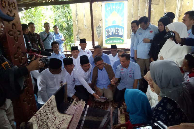Cawapres 02 Sandiaga Uno melihat kerajinan songket sumsel di Rumah Siap Kerja Palembang sebelum kampanye akbar, Jumat (12/4). (Antara)