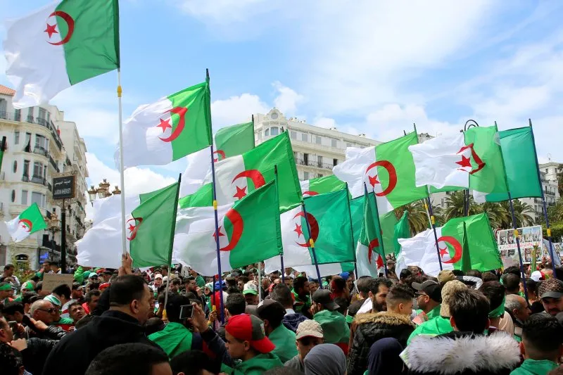 Orang-orang membawa bendera nasional selama protes mencari kepergian elit yang berkuasa, ketika negara itu bersiap untuk pemilihan presiden di Aljir, Aljazair 12 April 2019. (REUTERS / RAMZI BOUDINA) (REUTERS/RAMZI BOUDINA)	