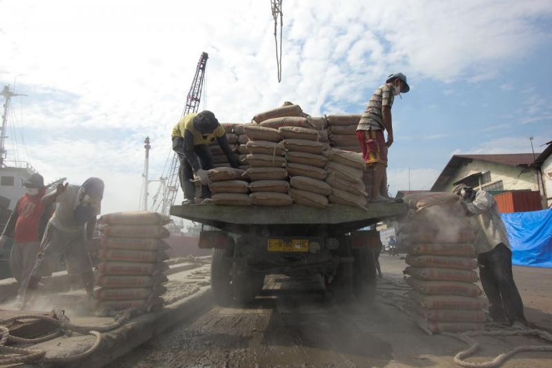 Pekerja menurunkan muatan semen (Media Indonesia)