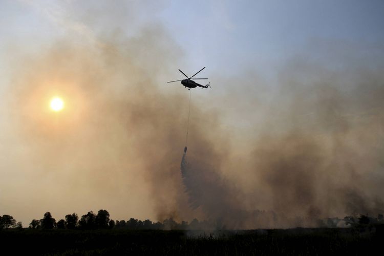 Pemadaman kebakaran hutan dan lahan dengan menggunakan helikopter. (Foto: Kompas.com)