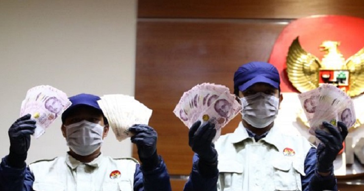Penyidik KPK menunjukkan barang bukti berupa uang pecahan dolar Singapura. (Foto: Tribunnews)