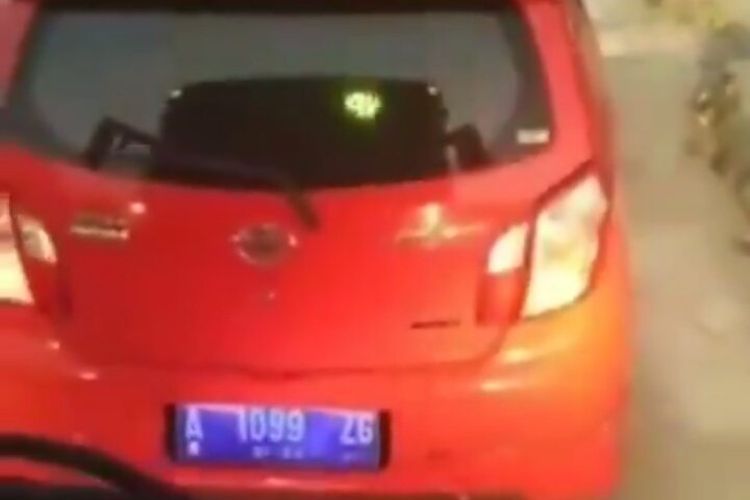 Sebuah mobil berwarna merah dengan pelat nomor A 1099 ZG menerobos masuk jalur transjakarta (Kompas.com)