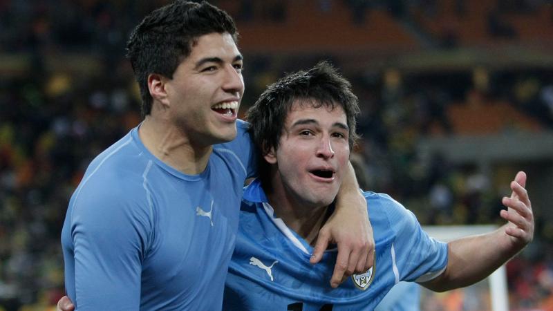 Luis Suarez (kiri) merangkul rekannya Nico Lodeiro  ketika keduanya membela Uruguay dalam sebuah pertandingan internasional (Andrew Boyers/Action Images)