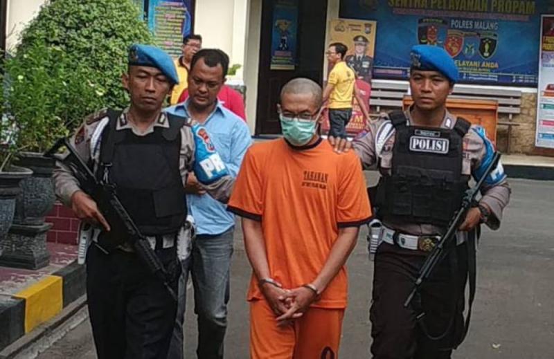 Guru berinisial CH (tengah) dibawa polisi di Mapolres Malang (Foto: Okezone.com/Avirista)
