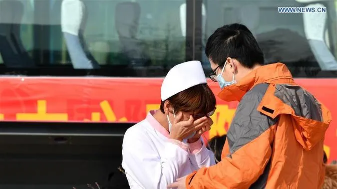 seorang istri melepas kepergian suaminya ke kota Wuhan (Liputan6.com)