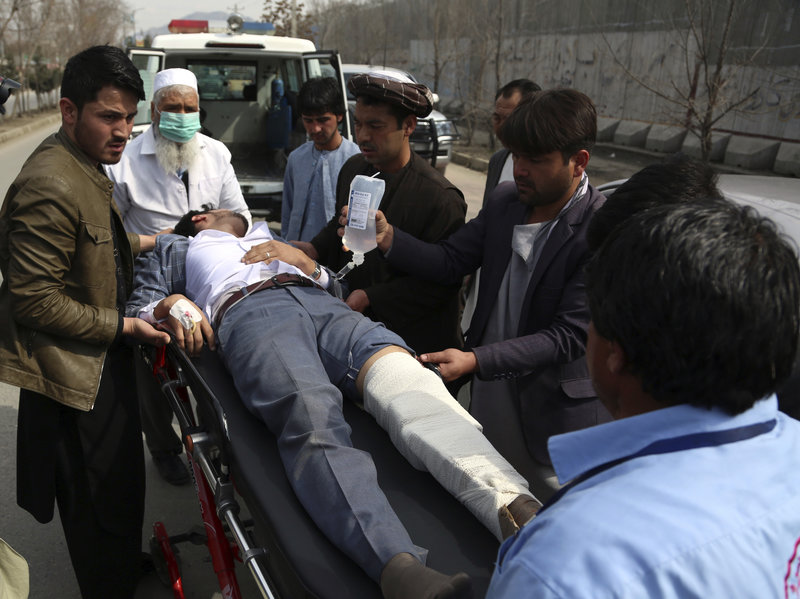 Petugas medis dan warga mengevakuasi warga yang tertembak ke dalam Ambulance (Rahmat Gul /AP)