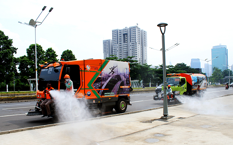 Petugas menyemprotkan cairan disinfektan di Pedestrian Jalan Jenderal Sudirman, Jakarta, Jumat (27/3). Penyemprotan rutin guna mencegah peyebaran virus corona. Robinsar Nainggolan