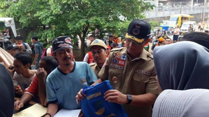 Menteri Sosial Juliari Batubara saat berikan bantuan kepada korban banjir (tribunnews)