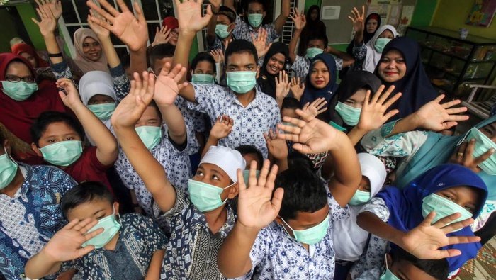 Sejumlah siswa penyandang disabilitas, guru dan petugas kesehatan berfoto bersama usai mengikuti sosialisasi tata cara penggunaan masker tepat dan benar di Sekolah Luar Biasa (SLB) Cinta Mandiri, Panggoi, Lhokseumawe, Aceh, Jumat (6/3/2020). (ANTARA FOTO/Rahmad/aww) 