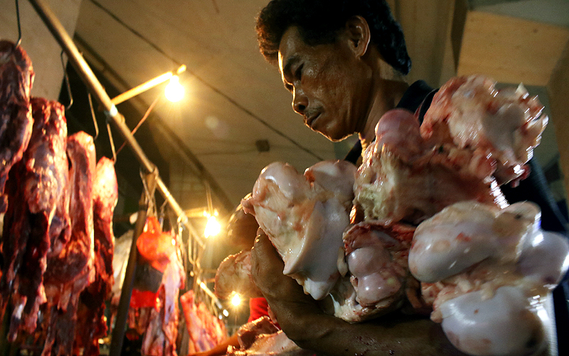 Somad (38 tahun) tampak kelelahan setelah mengangkat karung daging seberat seratus kilogram di Pasar Kebayoran Lama, Jakarta Selatan, Kamis (11/6). Para kuli panggul ini di upah sebesar seratus ribu rupiah untuk mengantarkan daging kepada para penjual daging dipasar tersebut. Robinsar Nainggolan