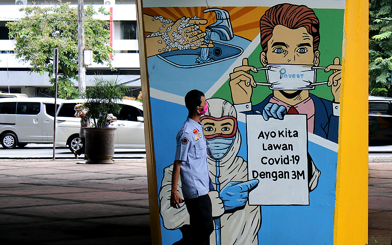 Masyarakat melintas di depan mural imbauan untuk melawan COVID-19 di kawasan Tomang, Jakarta. Penambahan jumlah kasus positif terkonfirmasi virus corona (Covid-19) di Indonesia per hari mencapai empat ribuan lebih. Mural ini berupa ajakan masyarakat agar patuhi protokol kesehatan. Robinsar Nainggolan
