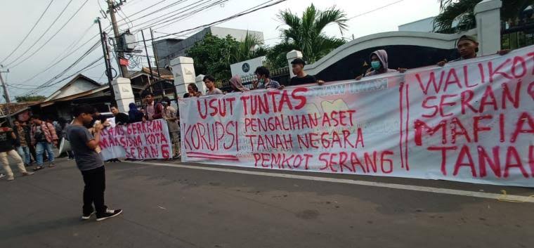 Sejumlah mahasiswa membentangkan spanduk yang berisi tuntutan agar kasus korupsi tanah Batok yang melibatkan Wali Kota Serang diusut. (Foto: TitikNOL)