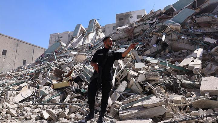 Polisi mengamati reruntuhan Gedung al-Jalaa yang menampung kantor media Associated Press (AP) dan Al Jazeera yang runtuh terkena serangan udara Israel di Kota Gaza, 15 Mei 2021. REUTERS/Mohammad Salem