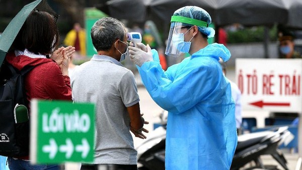 Ilustrasi: Pemeriksaan suhu tubuh di tengah pandemi virus Corona di Vietnam (Foto: BBC World)