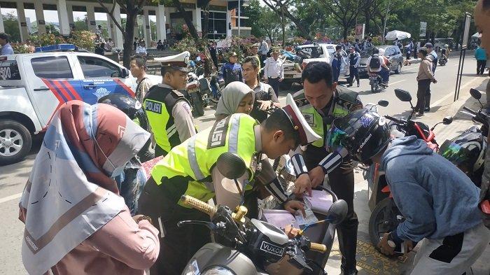 Polisi menilang pengendara motor (Foto: Tribunnews)