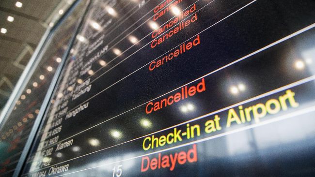 Foto papan informasi penerbangan di bandara Hong Kong. (AFP PHOTO / Anthony WALLACE)