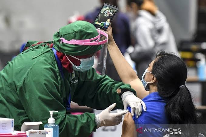 Vaksinator menyuntikkan vaksin COVID-19 Sinovac dosis pertama ke seorang tenaga kesehatan saat vaksinasi massal di Istora Senayan, Jakarta, Kamis (4/2/2021). (Foto: Antara).
