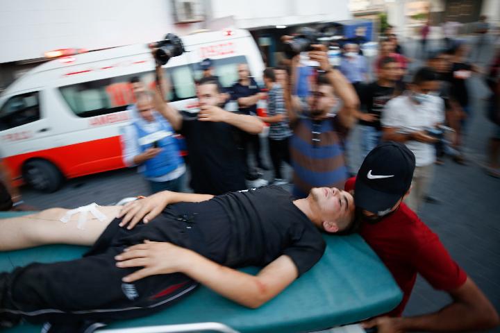 Seorang warga Palestina yang terluka dibawa dengan tandu setelah mengikuti protes di perbatasan Israel-Gaza di timur Kota Gaza, Sabtu (21/8/2021). (Foto: Reuters).