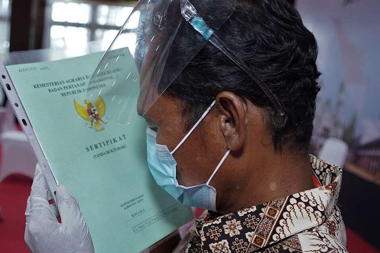 Warga mencium sertifikat usai mengikuti penyerahan sertifikat tanah gratis oleh Presiden Joko Widodo secara virtual, di Rujab Gubernur Sulawesi Tenggara, Kendari, Sulawesi Tenggara, Selasa (5/1/2021). (ANTARA)