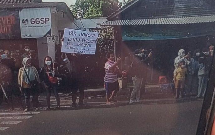 Seorang Peternak ayam nekat bentangkan poster disela kunjungan Jokowi di Blitar Jawa Timur (IDNews)