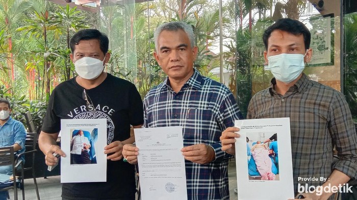 Foto: Pengacara PT Propernas Nusa Dua, Sastra (tengah), bersama keluarga korban menunjukkan foto kedua korban usai ditusuk OTK. (Arfah-detik).