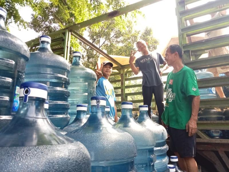 Pekerja agen air minum kemasan sedang memindahkan galon air minum untuk segera di distribusikan ke toko, di Jakarta, Selasa (15/11) (Devi Puspitasari/Law-Justice.co)