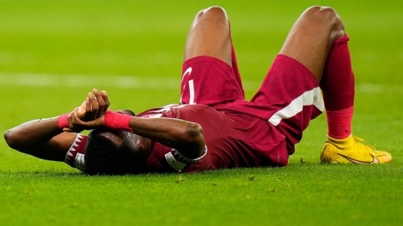 Pemain Timnas Qatar Ismail Mohamad Lies berbaring di lapangan setelah kalah 1-3 dari Senegal. (Foto: AP Photo)