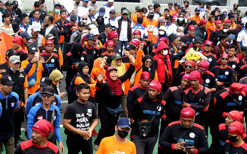 Buruh berdemonstrasi di depan gedung DPR/MPR RI, Jalan Jenderal Gatot Subroto, Jakarta. Pagar kawat berduri dipasang di depan gerbang gedung DPR. Sebanyak 1.623 personel gabungan dikerahkan untuk mengamankan demonstrasi buruh, Senin (6/2/2023). menolak Peraturan Pemerintah Pengganti Undang-Undang (Perppu) Cipta Kerja, dan Rancangan Undang-Undang (RUU) Kesehatan Omnibus Law. Robinsar Nainggolan
