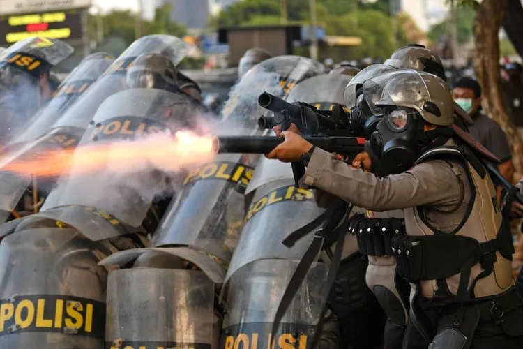 Seorang polisi menembakkan pelontar gas air mata saat kericuhan dalam unjuk rasa di Jalan Gatot Subroto, dekat kompleks Parlemen, Jakarta, Senin (30/9/2019). Unjuk rasa gabungan pelajar dan mahasiswa yang menolak UU KPK dan pengesahan RUU KUHP tersebut berakhir ricuh. ANTARA FOTO/Aditya Pradana Putra/ama.