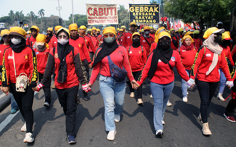 Ribuan buruh gelar aksi unjuk rasa di kawasan Patung Kuda, Jakarta, Senin (2/10/2023) dan jalanan di sekitar kawasan itu ditutup. Massa buruh yang menggelar demonstrasi menuntut omnibus law UU Cipta Kerja dicabut melakukan aksi bakar ban. Mereka terlihat mengelilingi ban yang dibakar itu. Robinsar Nainggolan