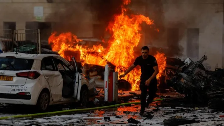 Foto: Seorang pria berlari di jalan saat api berkobar setelah roket diluncurkan dari Jalur Gaza, di Ashkelon, Israel 7 Oktober 2023. (REUTERS/AMIR COHEN)