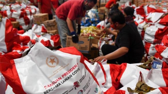 Ilustrasi: Pekerja mengemas paket bantuan sosial (bansos) di Gudang Food Station Cipinang, Jakarta, Rabu (22/4/2020). (Suara)