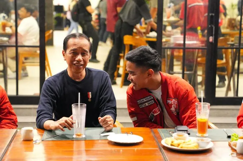 Presiden Joko Widodo (kiri) berbincang dengan Ketua UmumPartai Solidaritas Indonesia (PSI) Kaesang Pangarep (keduakanan) dan kader PSI saat melakukan pertemuan di kawasanJalan Braga, Bandung, Jawa Barat, Sabtu (3/1/2024). (JPNN) 