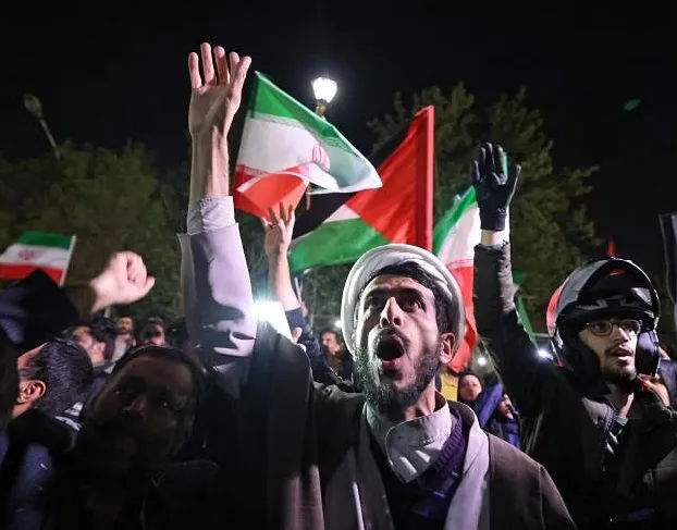 Pengunjuk rasa berkumpul di depan Kedutaan Besar Inggris di Teheran pada 14 April 2024. (AFP via Straits Time)