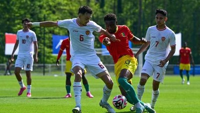 Gelandang Timnas Indonesia U-23 Ivar Jenner mengawal pemain Guinea, Kamis (9/5). (AFP/MIGUEL MEDINA)