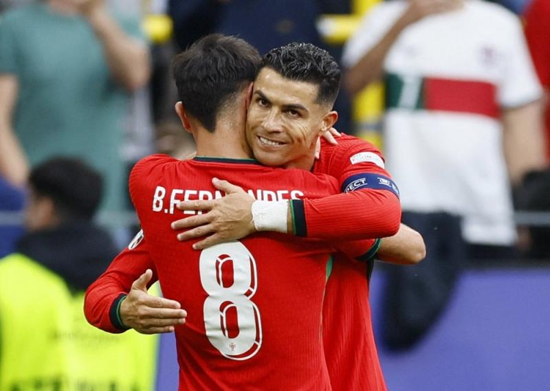 Cristiano Ronaldo memeluk Bruno Fernandes usai Timnas Portugal unggul 3-0 atas Timnas Turki di gelaran Euro 2024. (Reuters via Okezone)
