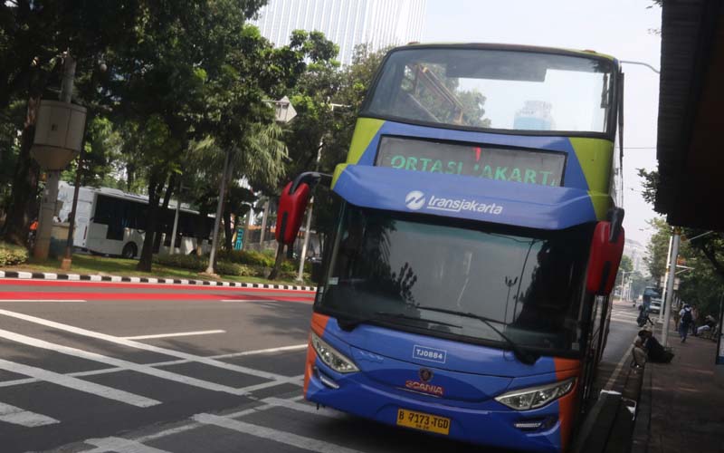 Sejumlah warga menikmati suasana kota dari atas bus wisata terbuka Transjakarta di halte Transjakarta IRTI Monumen Nasional (Monas), Gambir, Jakarta Pusat, Selasa (18/6/2024). Pada cuti bersama Hari Raya Idul Adha layanan bus wisata gratis Transjakarta diserbu antusias masyarakat yang tinggi untuk menikmati suasana kota Jakarta dan juga berswafoto di bus wisata tanpa atap tersebut. Robinsar Nainggolan