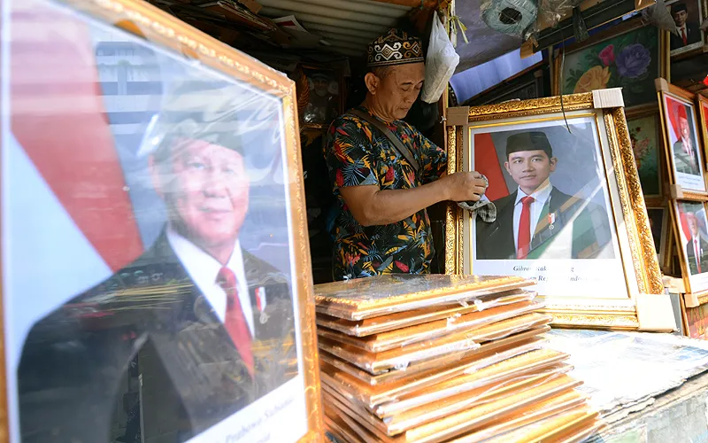 Pengrajin menerima lonjakan permintaan pigura foto Presiden dan Wakil Presiden Prabowo Subianto dan Gibran Rakabuming Raka terpilih masa bakti 2024-2029 di Pasar Baru, Jakarta, Selasa (29/10/2024). Penjualan pigura pasangan pemimpin Prabowo Subianto dan Gibran Rakabuming Raka masa bakti 2024-2029 tersebut meningkat drastis, dengan rata-rata 3.000 pasang terjual per hari. Harga pigura bervariasi dari Rp90 ribu hingga Rp950 ribu, tergantung ukuran. Fenomena ini menandakan antusiasme masyarakat ter