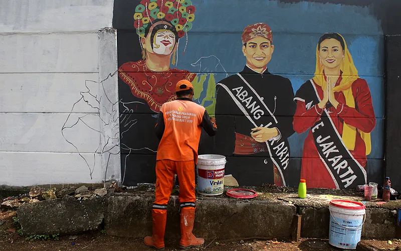 Petugas PPSU Kelurahan Bukit Duri menyelesaikan mural dengan tema keberagaman budaya Indonesia di kawasan Bukit Duri, Jakarta, Selasa (19/11/2024).  Pengerjaan mural dengan panjang 100 meter dan tinggi 2,5 meter tersebut dibuat dalam rangka penataan kawasan unggulan. Robinsar Nainggolan