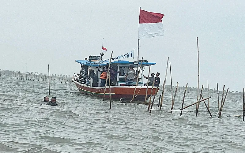 TNI Angkatan Laut (AL) bersama nelayan di Tanjung Pasir, Tangerang, Banten, mulai melakukan pembongkaran pagar laut yang dibangun tanpa izin pada Sabtu (18/1/2025). Pembongkaran ini merupakan langkah nyata untuk mengatasi keberadaan pagar laut sepanjang 30,16 kilometer yang telah menimbulkan polemik. Pagar laut tersebut diduga merusak ekosistem dan berdampak negatif terhadap aktivitas nelayan setempat. Robinsar Nainnggolan
