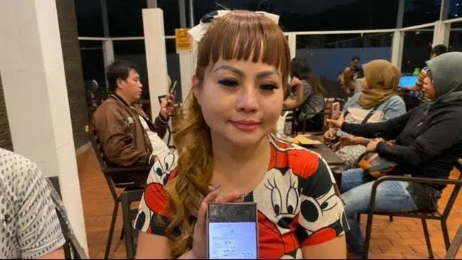 Pengusaha Surabaya, Jan Hwa Diana, menunjukkan surat bukti laporan polisi, Sabtu (12/4/2025). (Sumber: Kompas.com/Andhi Dwi)