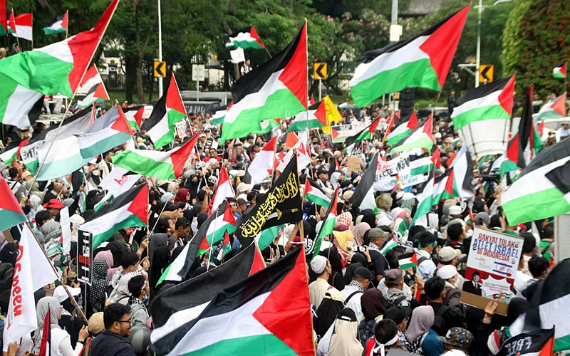 Massa aksi solidaritas untuk Palestina demo di depan Kedutaan Besar Amerika Serikat (AS), Jalan Medan Merdeka Selatan, Jakarta Pusat, Selasa (7/10/2025).  Aksi tersebut menuntut agar blokade Gaza dapat dibuka dan menghentikan aksi kekejian genosida oleh tentara Israel. Robinsar Nainggolan