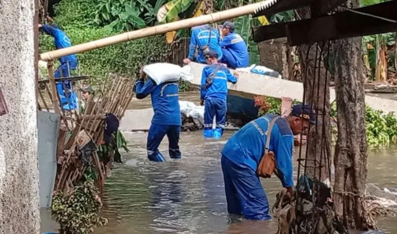 Petugas SDA berusaha menutupi tembok dengan karung pasir di samping Mushala Sabili, Jati Padang, Pasar Minggu, Jakarta Selatan yang jebol, Jumat (31/10/2025).  (Kompas.com)